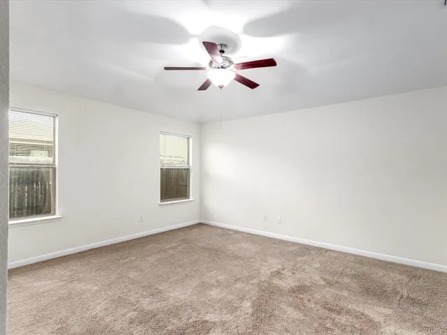 an empty room with closet and a ceiling fan