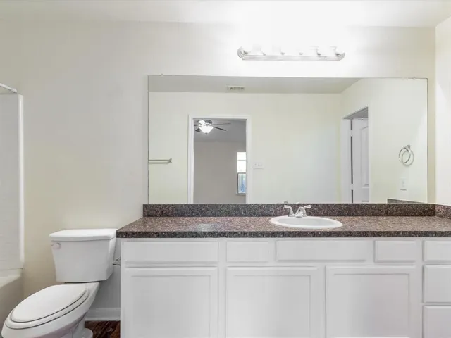 a view of a room with a ceiling fan and a window