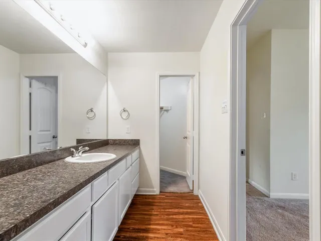 a bathroom with a granite countertop sink a toilet and shower