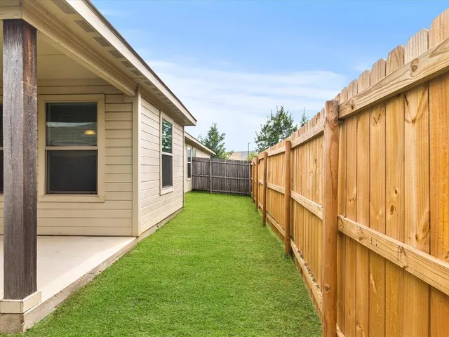 a view of a backyard with wooden fence