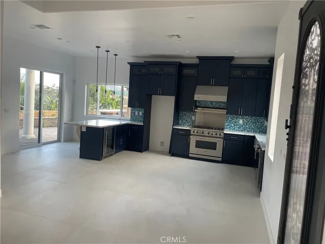 a kitchen with a refrigerator and a stove top oven