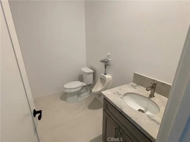 a bathroom with a granite countertop sink a toilet and a mirror