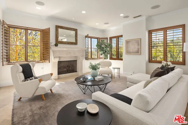 a living room with furniture fireplace and floor to ceiling windows