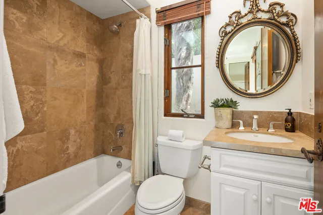 a bathroom with a granite countertop toilet a sink and a bathtub