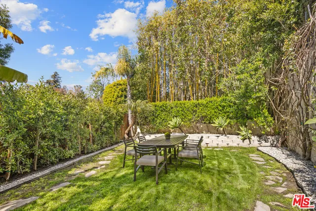 a garden with a bench and some trees