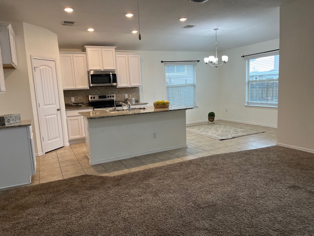 505 Ibis Falls Loop Jarrell, TX 76537 - Photo 29 of 29 a kitchen with stainless steel appliances granite countertop a refrigerator a sink a stove and white cabinets with wooden floor