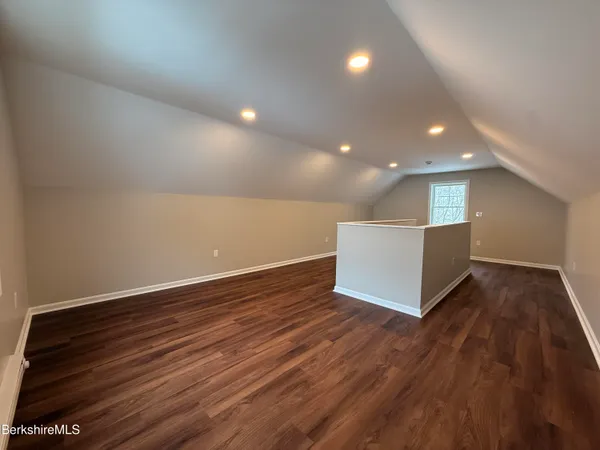 an empty room with wooden floor and entrance