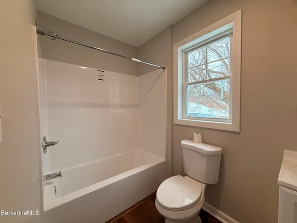 a white toilet sitting next to a bath tub shower