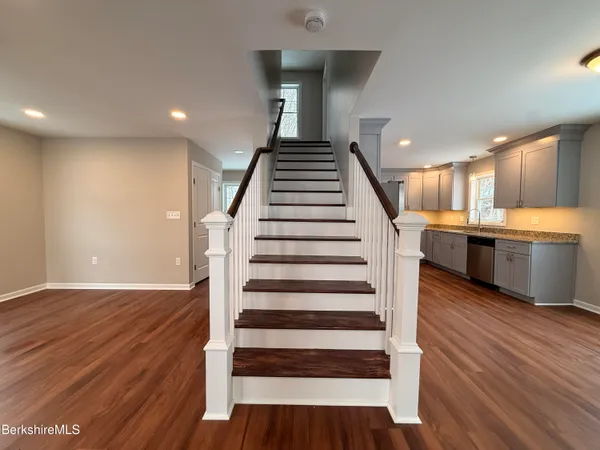 a view of a room with wooden floors and kitchen appliances