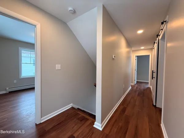 a view of a hallway with wooden floor