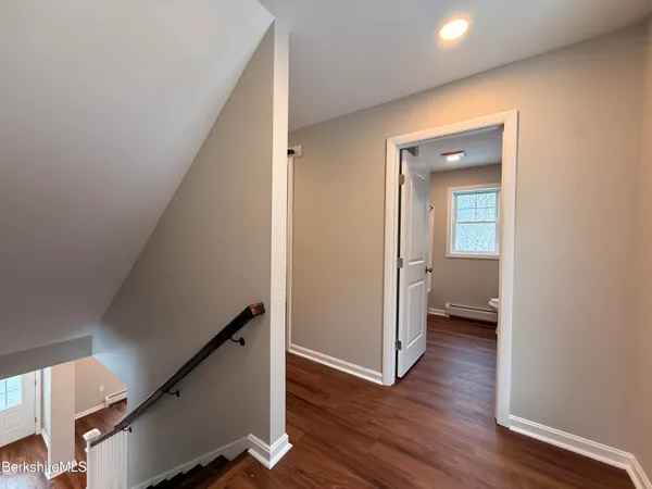 a view of a hallway with wooden floor and staircase