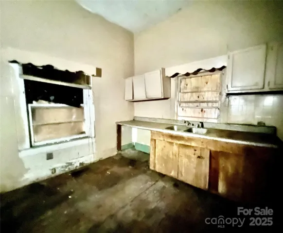 a kitchen with granite countertop a stove a sink and a microwave