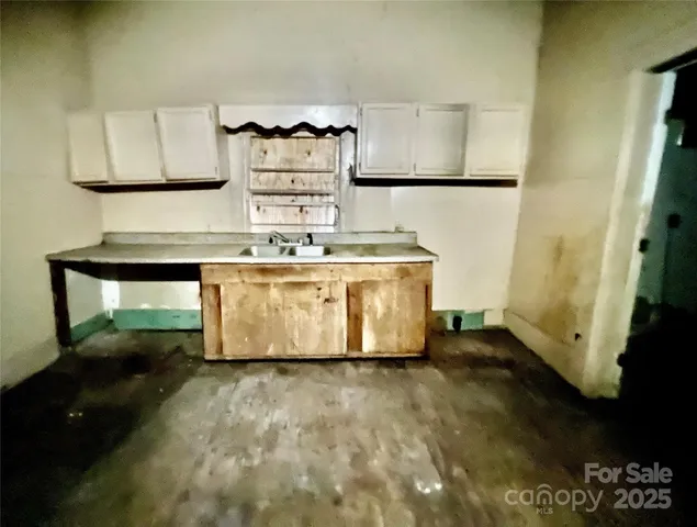 a view of kitchen with stainless steel appliances granite countertop a sink a stove and a refrigerator