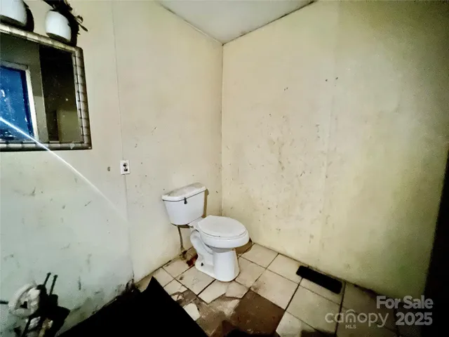 a bathroom with a toilet and a shower curtain