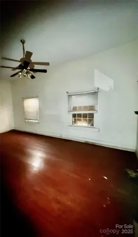 an empty room with a wooden floor and windows