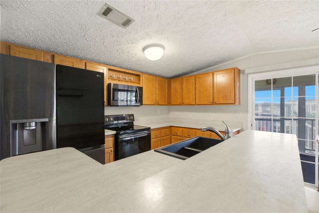 15 North Cardinal, Unit B15 Punta Gorda, FL 33950 - Photo 10 of 49 a large kitchen with stainless steel appliances granite countertop a refrigerator and a sink