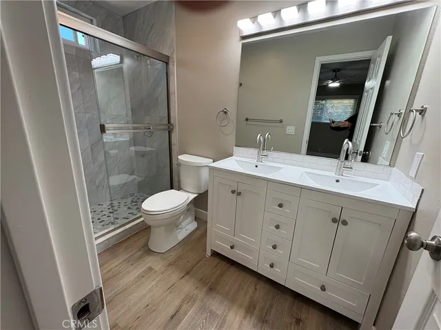 a spacious bathroom with a double vanity sink toilet and shower