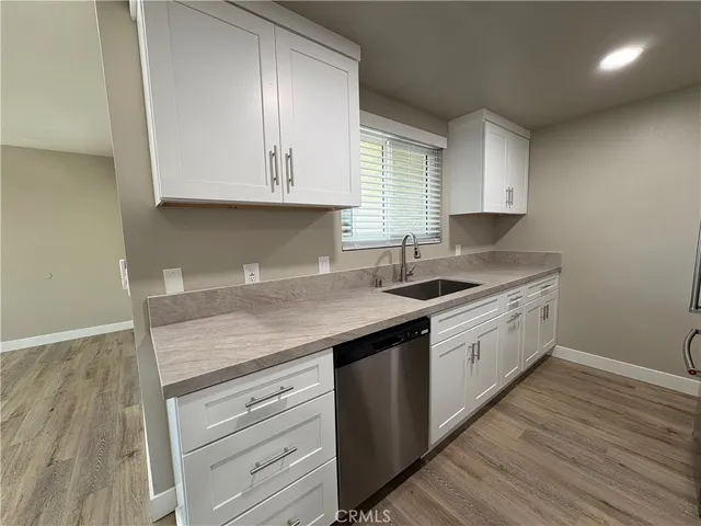 a kitchen with granite countertop white cabinets and a sink