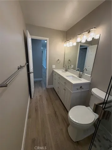 a bathroom with a sink a toilet a mirror and shower