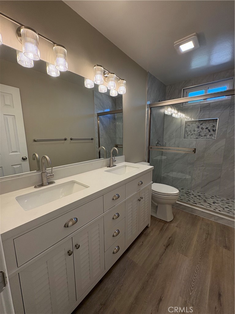 33972 El Encanto Avenue, Unit D Dana Point, CA 92629 - Photo 36 of 46 a bathroom with a double vanity sink a toilet and a mirror