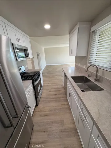 a kitchen with stainless steel appliances granite countertop a sink and a stove