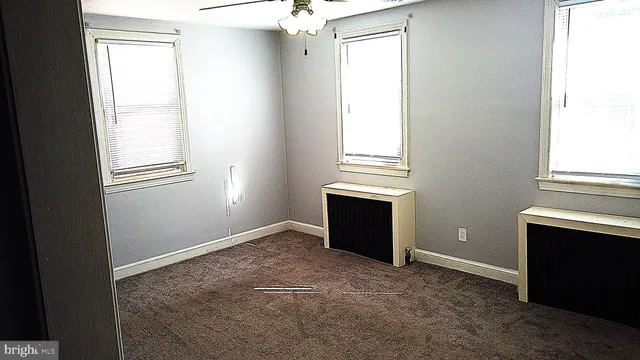 an empty room with windows and closet