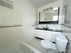 a kitchen with a refrigerator and white cabinets