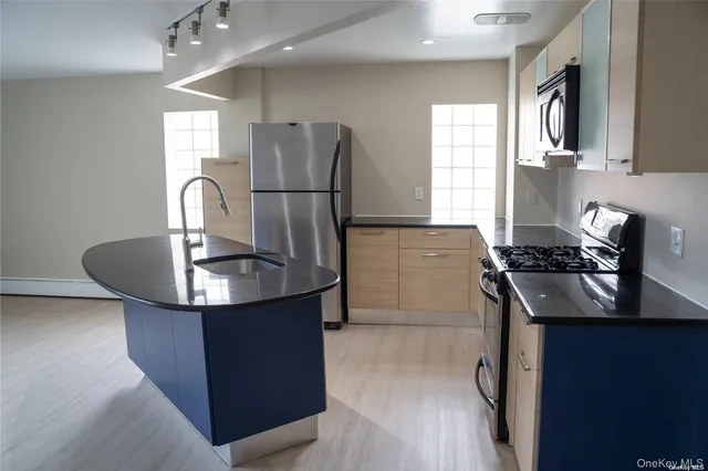 a view of a big room with kitchen view and windows