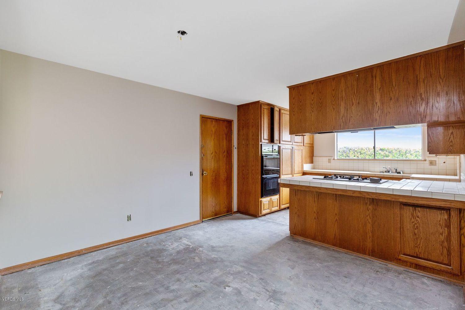 26003 Adamor Road Calabasas, CA 91302 - Photo 4 of 16 a kitchen with stainless steel appliances a sink a stove a refrigerator cabinets and a counter top space