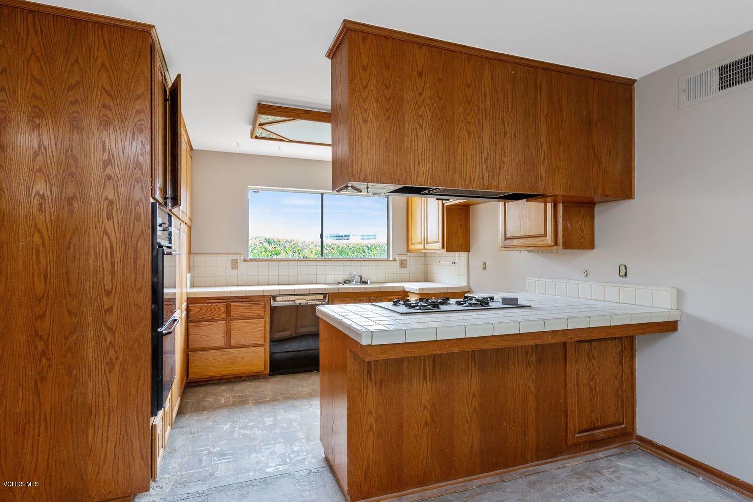 26003 Adamor Road Calabasas, CA 91302 - Photo 5 of 16 a kitchen with a sink stove and cabinets