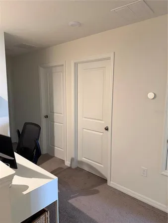 a view of a workspace with furniture and a window