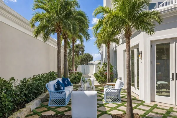 a view of a patio with table and chairs potted plants and palm tree