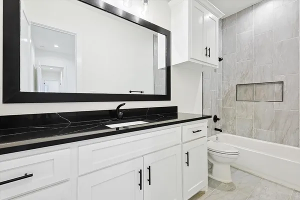 a bathroom with a bathtub a sink a toilet and a mirror