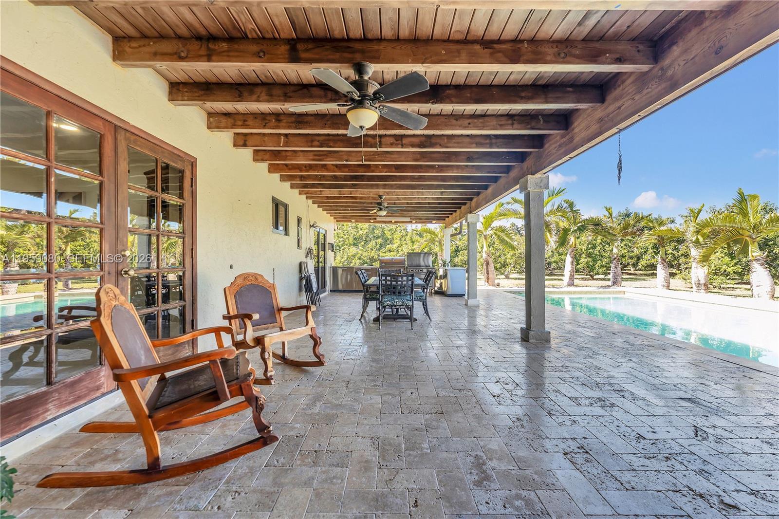19225 Southwest 186th Street Miami, FL 33187 - Photo 28 of 42 a view of a patio with table and chairs next to a large window with wooden floor