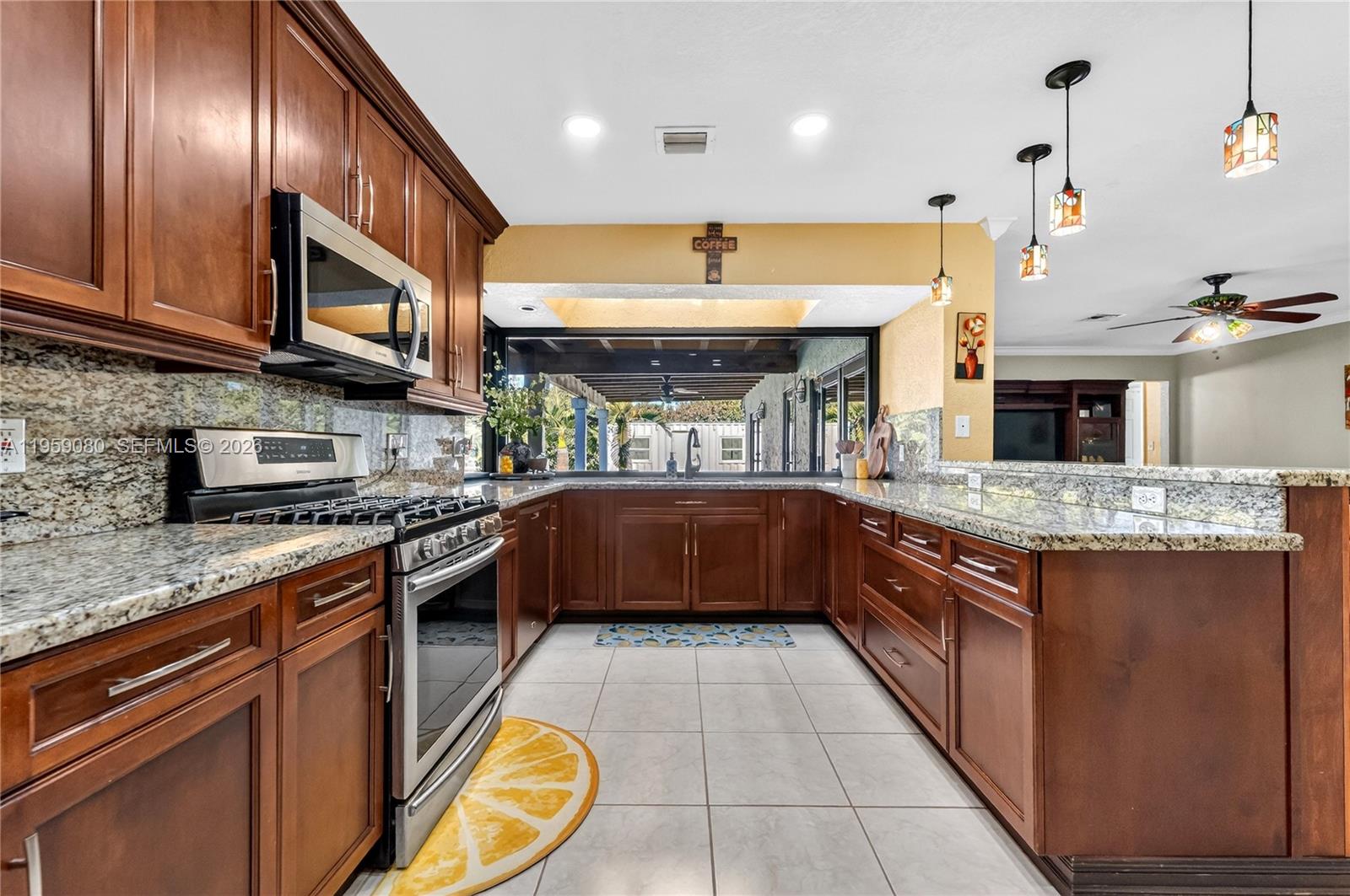 19225 Southwest 186th Street Miami, FL 33187 - Photo 3 of 42 a kitchen with stainless steel appliances granite countertop a large stove a sink dishwasher and cabinets with wooden floor