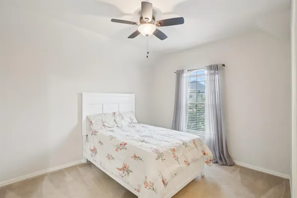 a bedroom with a bed and a ceiling fan