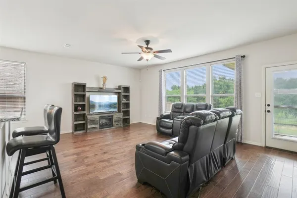 a living room with furniture a ceiling fan and a window