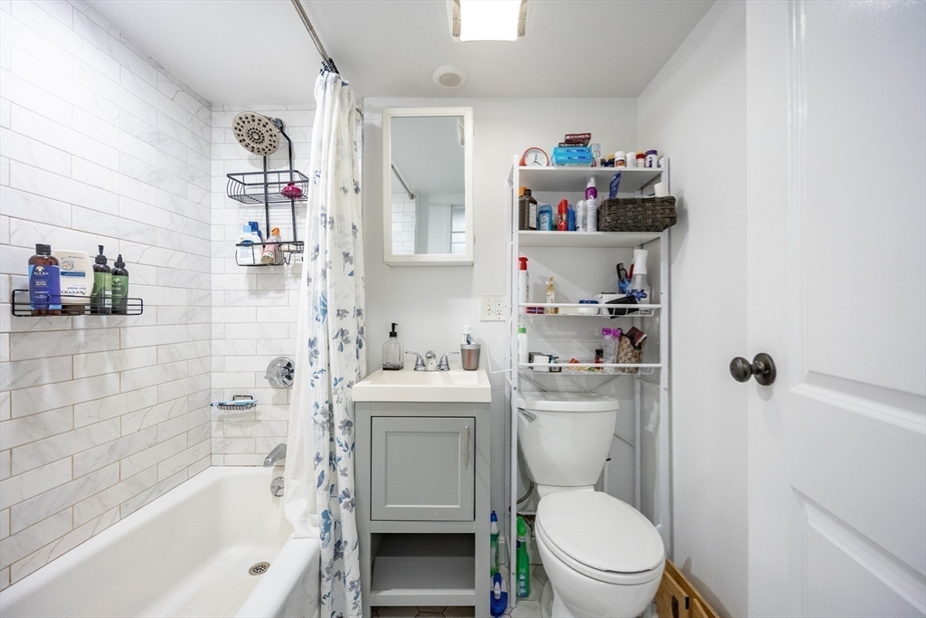 8 Avon Street, Unit 10 Somerville, MA 02143 - Photo 16 of 18 a bathroom with a sink toilet vanity mirror and shower