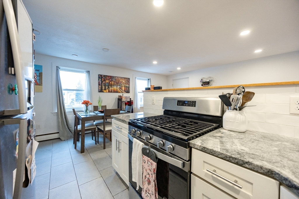 8 Avon Street, Unit 10 Somerville, MA 02143 - Photo 6 of 18 a kitchen with stainless steel appliances granite countertop a stove a sink and a microwave