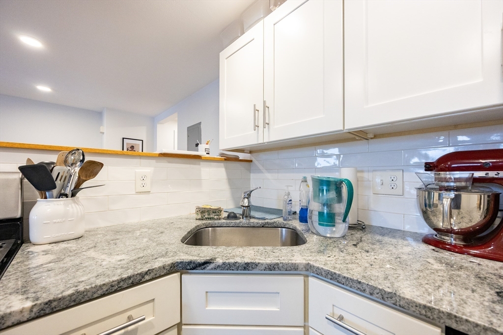 8 Avon Street, Unit 10 Somerville, MA 02143 - Photo 8 of 18 a kitchen with stainless steel appliances granite countertop a sink a stove and white cabinets
