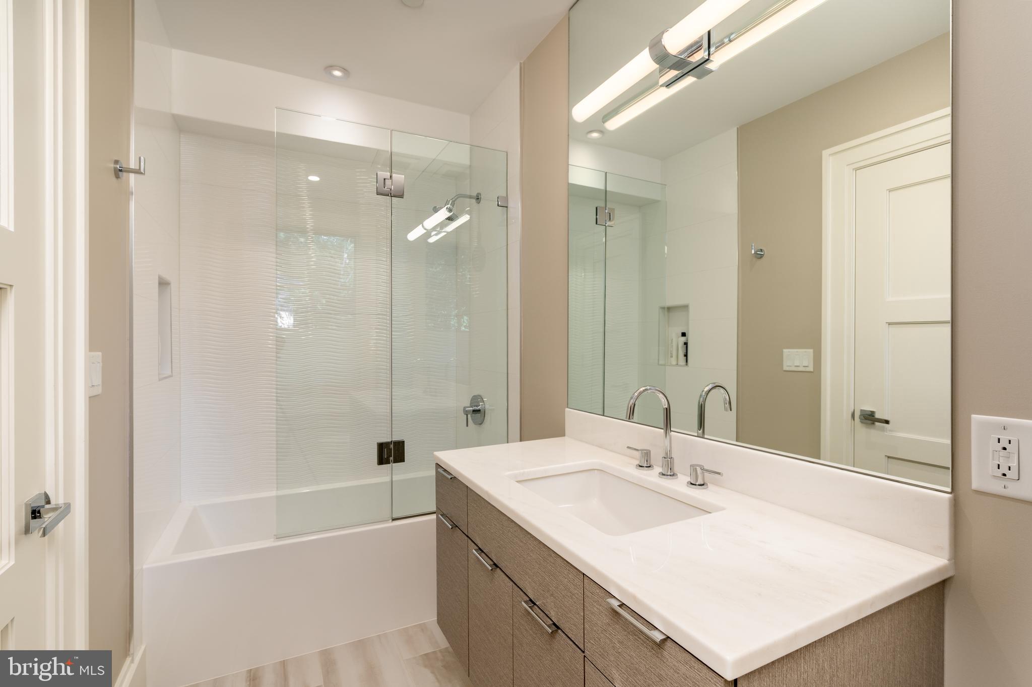 3128 Appleton Street Northwest Washington, DC 20008 - Photo 43 of 80 a bathroom with a sink double vanity granite tub shower and a mirror