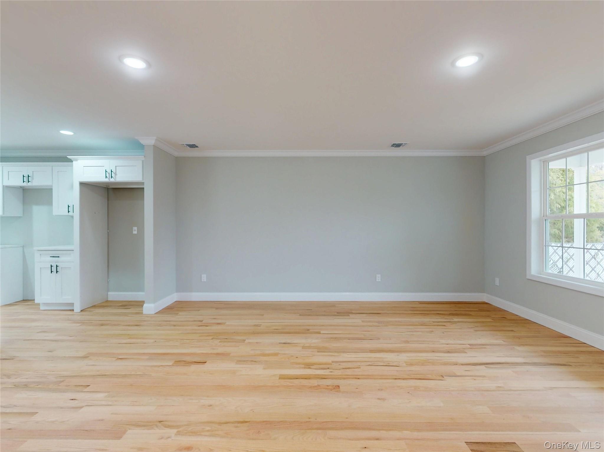492 Blue Point Road Farmingville, NY 11738 - Photo 4 of 21 an empty room with wooden floor and windows