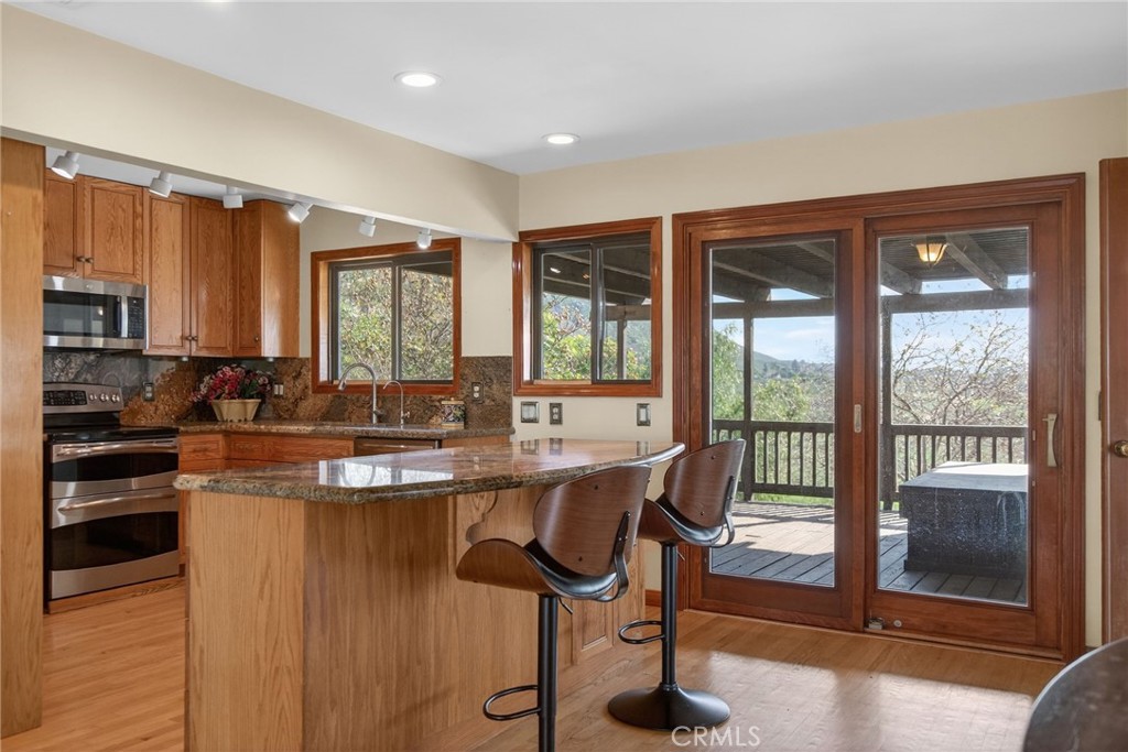 20682 Hill Top Drive Riverside, CA 92507 - Photo 11 of 70 a kitchen with stainless steel appliances granite countertop a stove a sink and a refrigerator