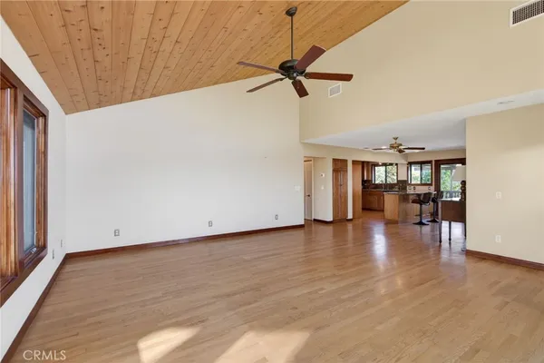 a view of a big room with wooden floor and windows