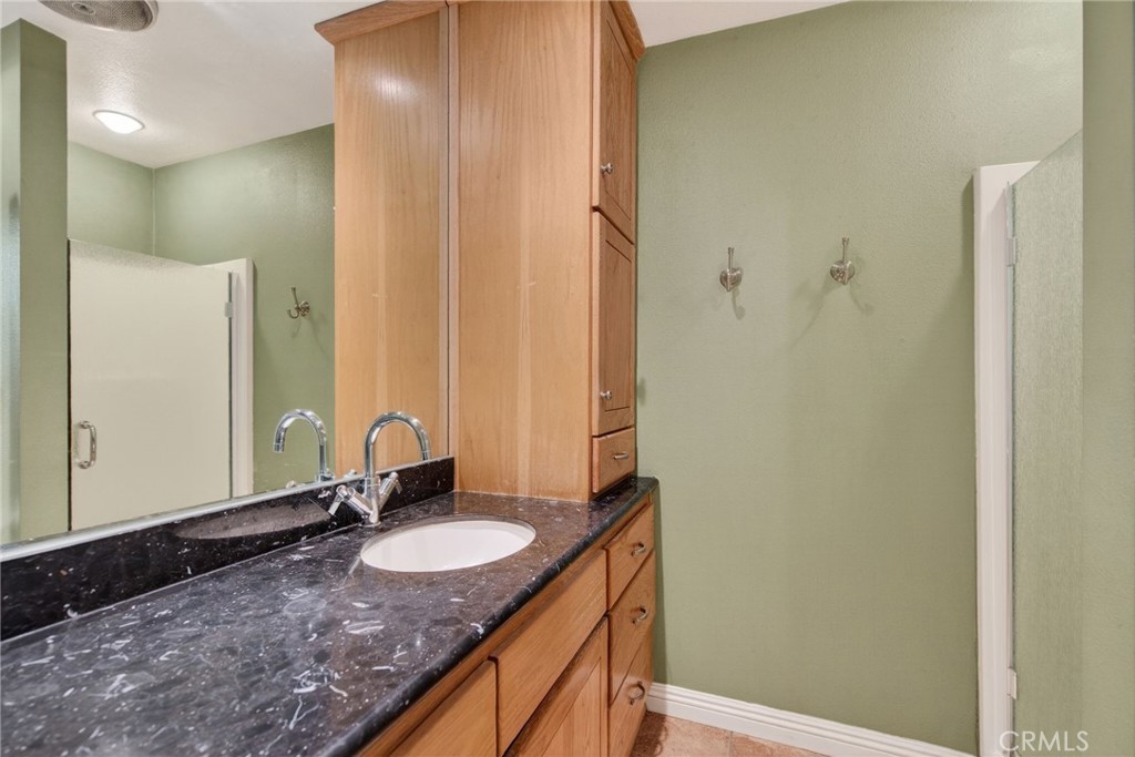 20682 Hill Top Drive Riverside, CA 92507 - Photo 46 of 70 a bathroom with a granite countertop sink and a mirror