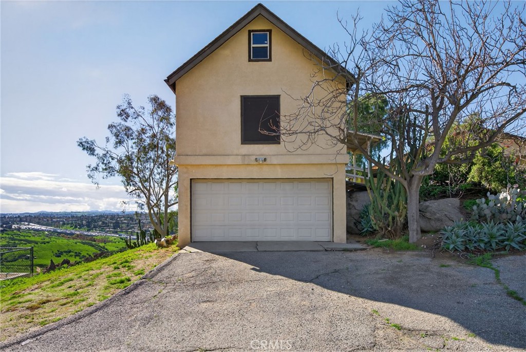 20682 Hill Top Drive Riverside, CA 92507 - Photo 64 of 70 a front view of a house with a yard and garage