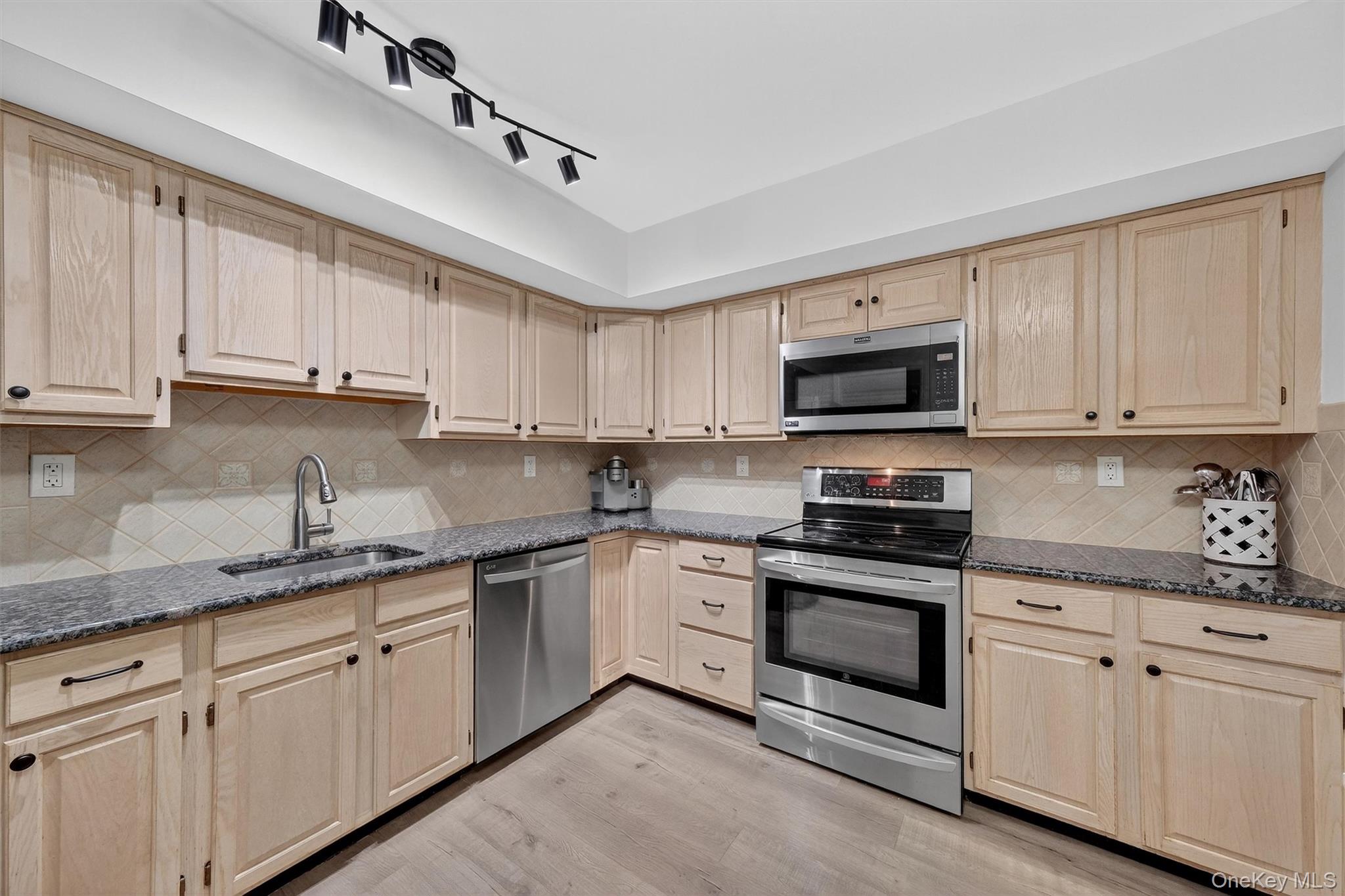 2 Deer Crossing Drive Fishkill, NY 12524 - Photo 19 of 49 a kitchen with granite countertop white cabinets sink and stainless steel appliances