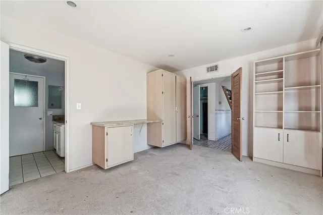 a kitchen with a refrigerator and white cabinets