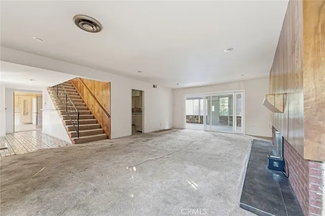 a view of an empty room with a fireplace and a window