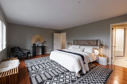 a bedroom with a bed and wooden floor